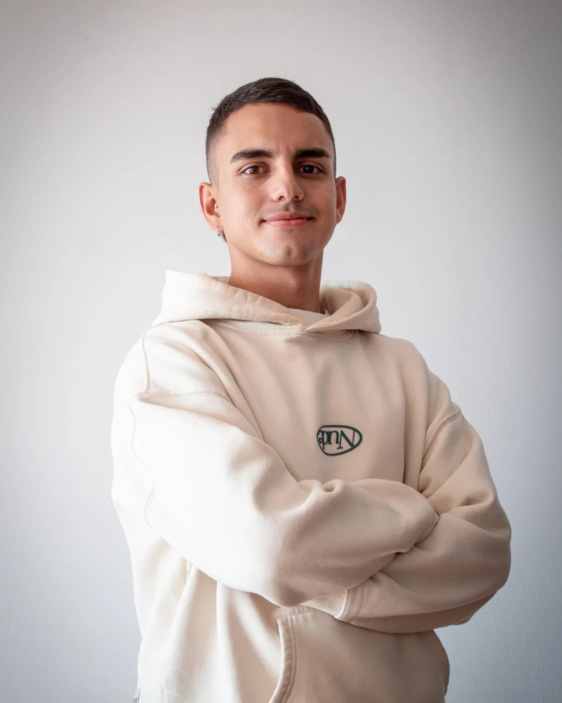 Retrato de Cristian Torres con los brazos cruzados sobre fondo claro